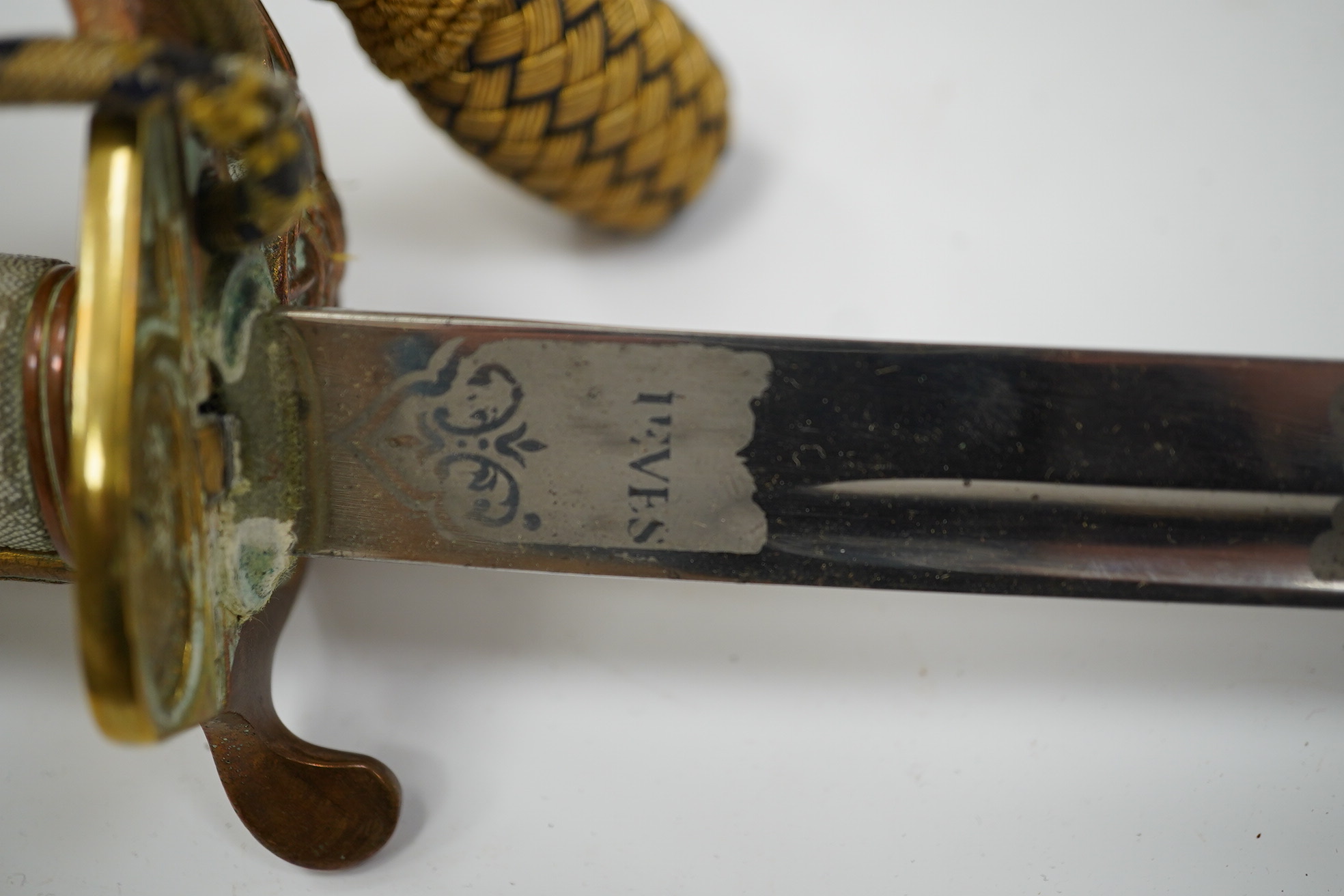 An 1846 pattern naval officer’s sword by Gieves, with folding thumb guard and knot, in its leather scabbard with brass mounts. Together with its outer soft leather cover. Condition - fair, notable wear to grip.